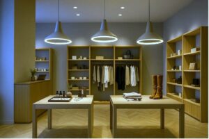 Dekorativa pendellampor framhäver varor på ett utställningsbord i en modern butik