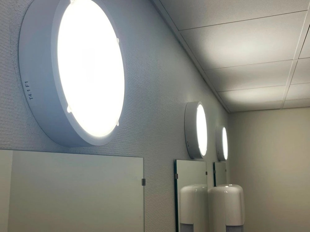 ALED Brida CCT hvid LED-plafond monteret over spejl i fællesareal