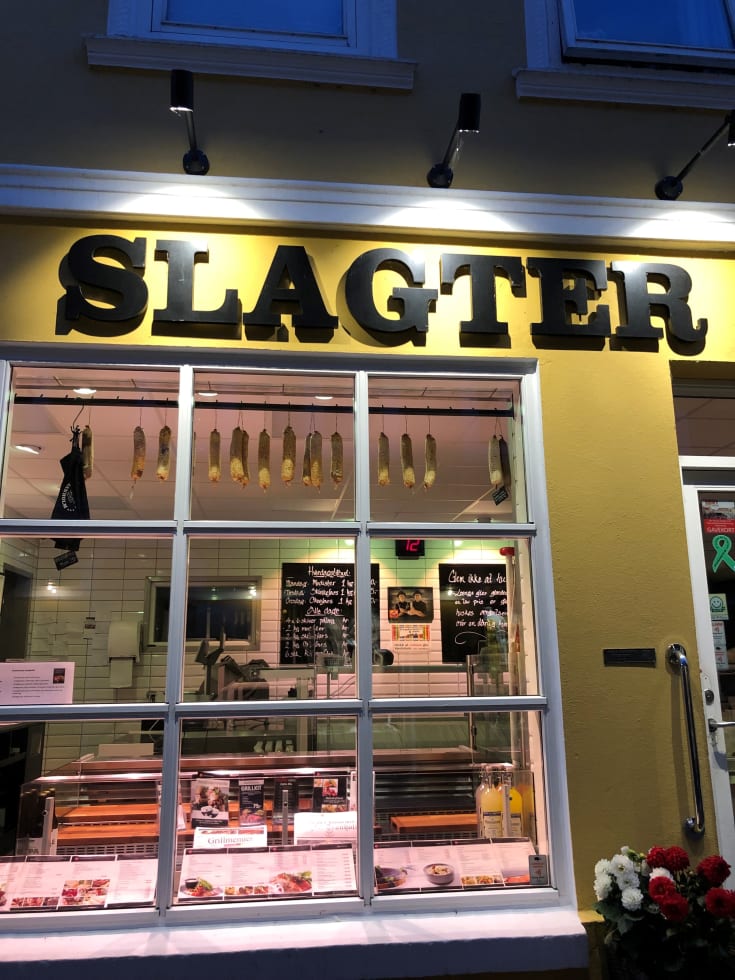 Scan Products Inna Sign sort skiltebelysning monteret over butiksskilt